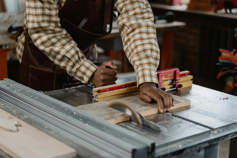 a man in plaid shirt working on wood