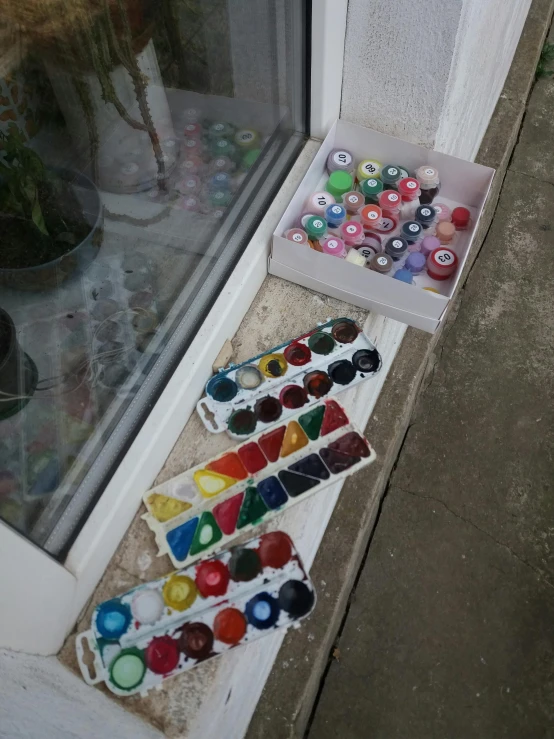 a glass window with a box full of cupcakes and paint in front