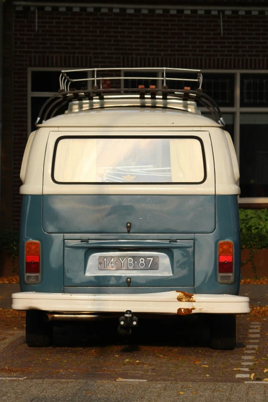 an old blue and white van parked in a parking lot