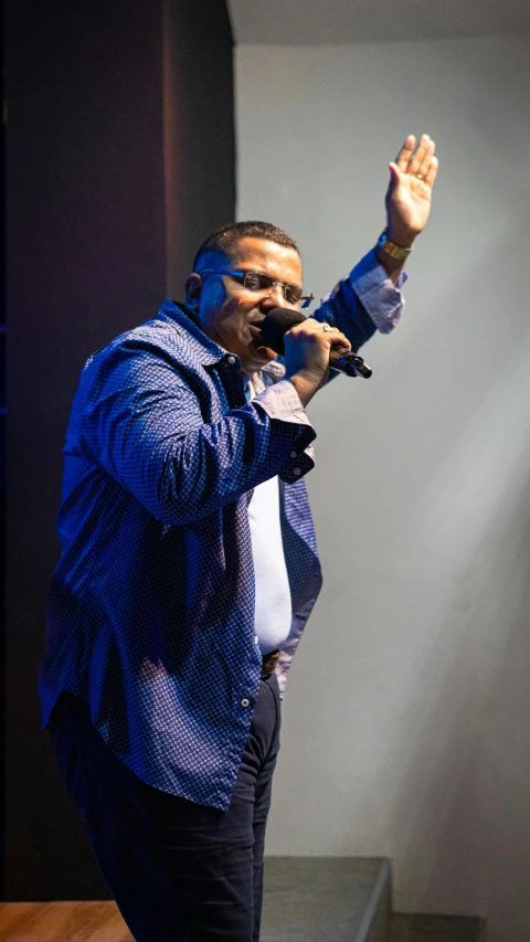 an individual doing a hand gesture while performing on stage