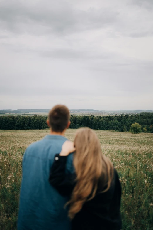 a man and woman are standing in the grass