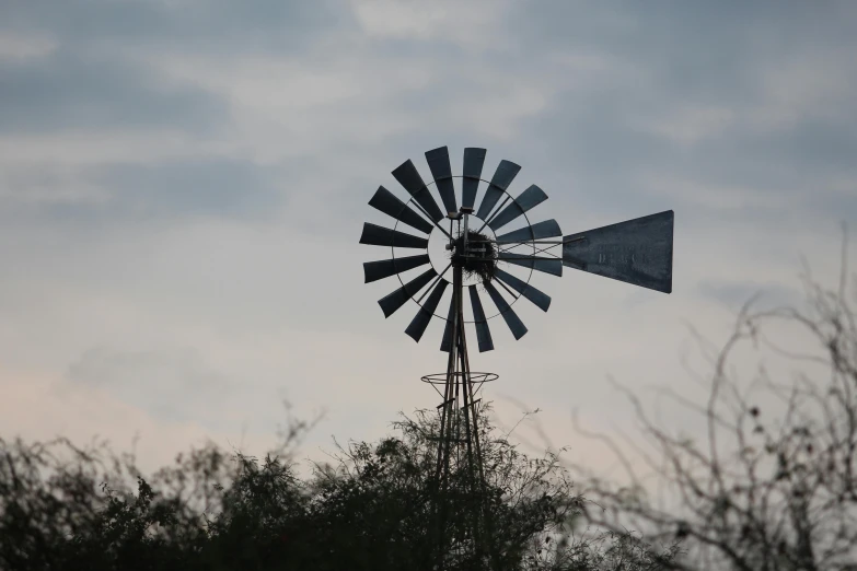 a close up s of a windmill with trees behind it