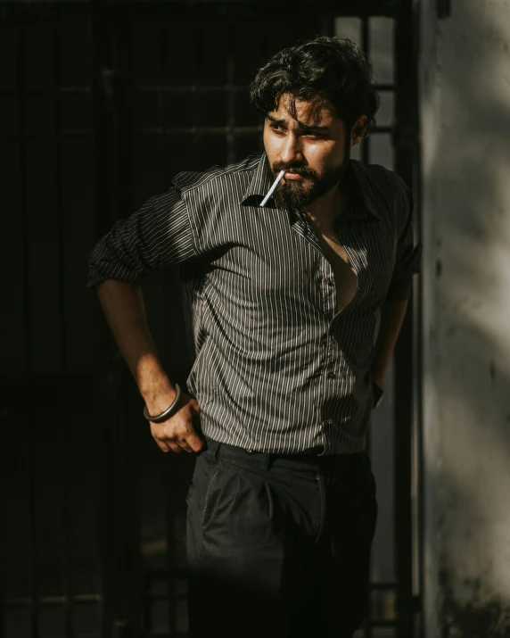 a man standing in a doorway while smoking a cigarette