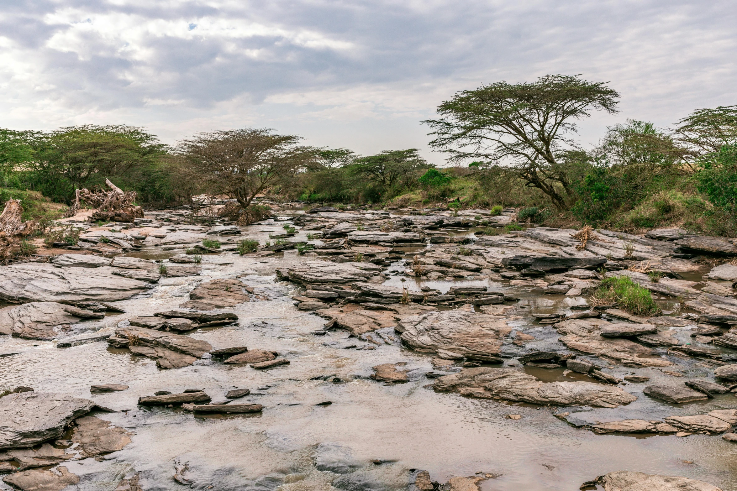 a stream flowing between some rocks to the sky