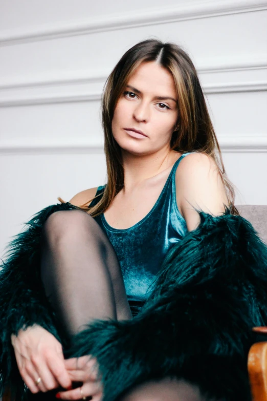 a woman sitting on top of a wooden chair