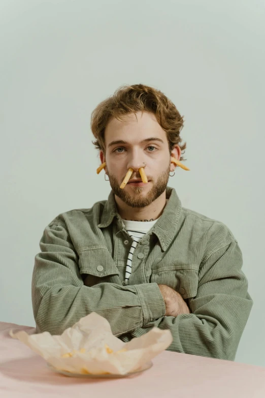 a man with two pins in his ear sitting at a table