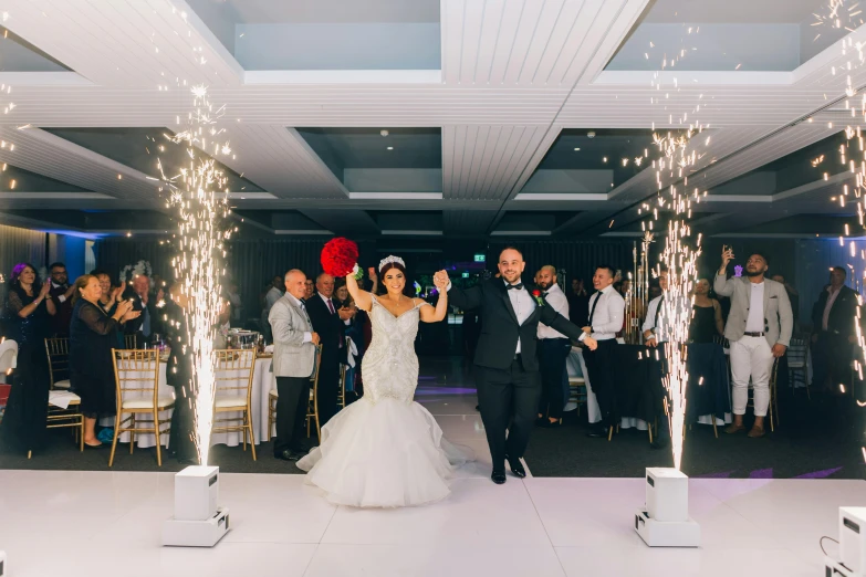 a couple walking down the aisle under sparklers