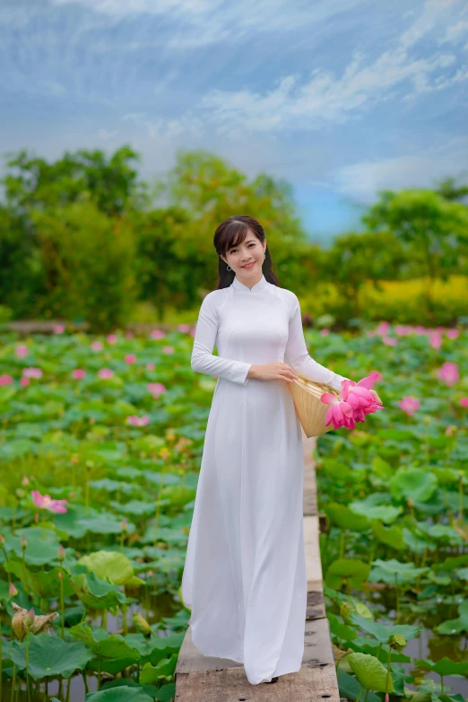 the woman is walking across a wooden plank holding a pink rose