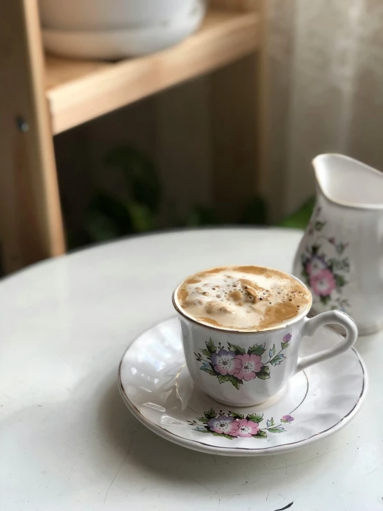 two coffee cups on a saucer on a table