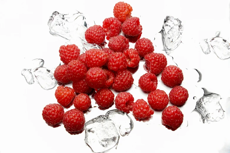 raspberries in ice cubes are shown on a white table