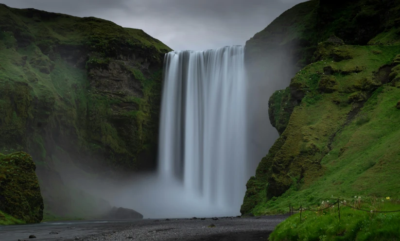 waterfall with large amount of water falling down over a road