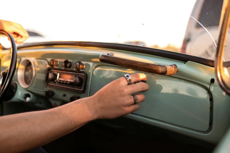 a person with their hand on the handle of an old vehicle