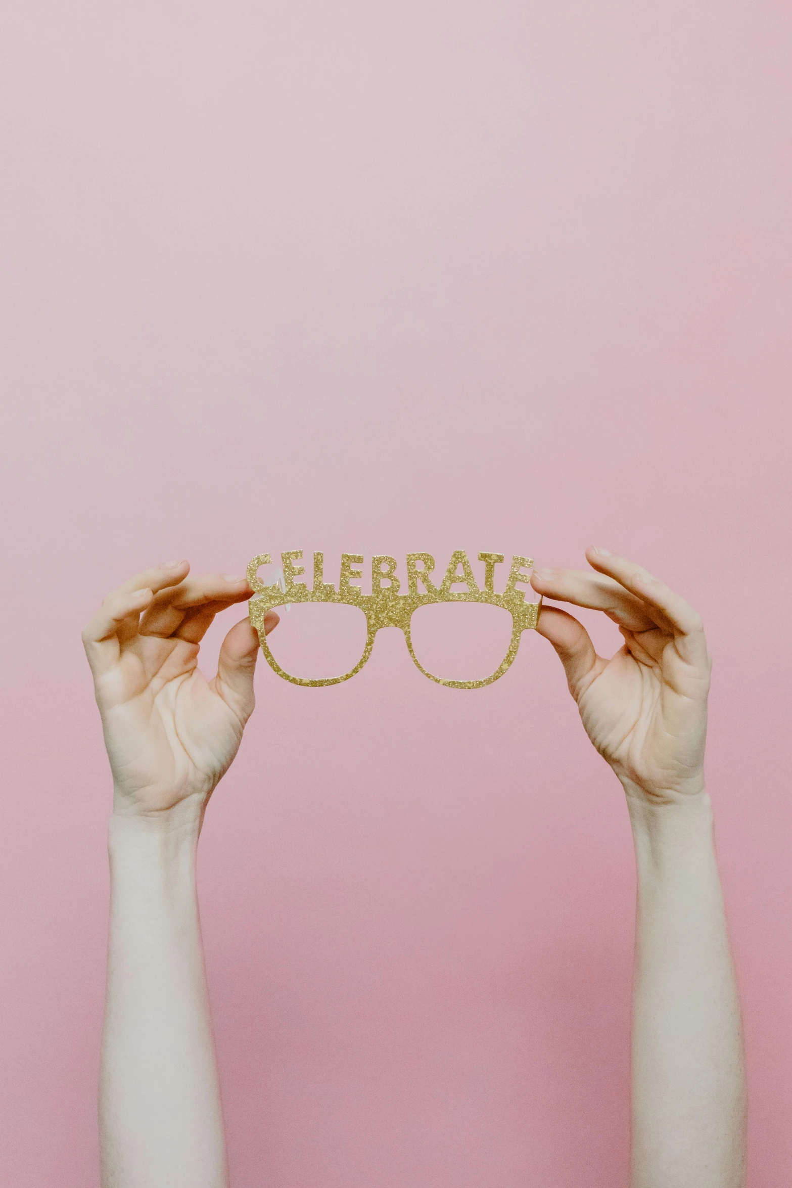 a person holds up a gold sunglasses that reads'cheerria '