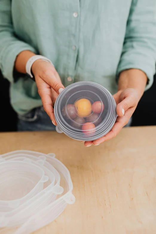 woman holding up plastic container with eggs in it