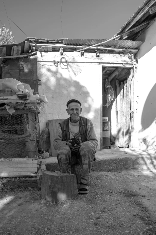 a man in overalls sits on a bench