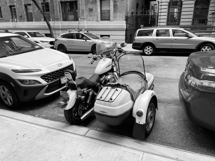 motor bike parked near cars in the city