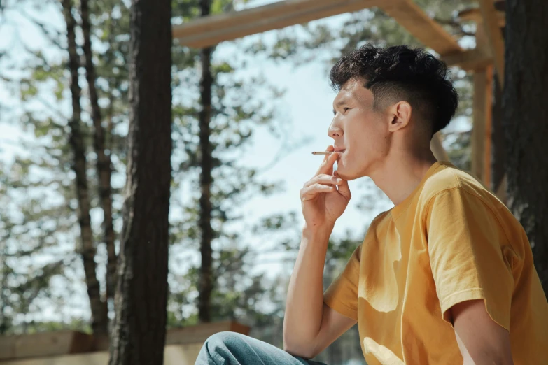 a man sitting in the shade next to some trees