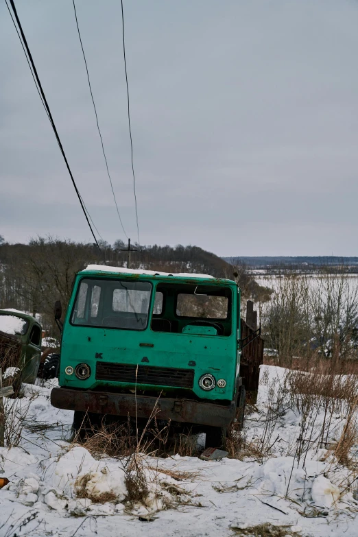 an old truck is sitting in the snow