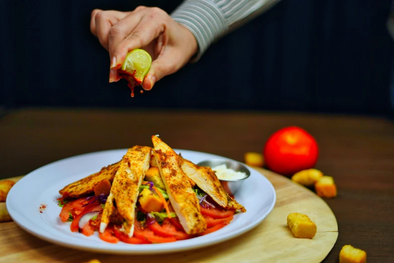 someone putting a piece of lime into a pile of food