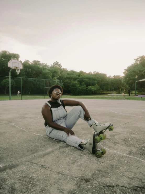 a man sitting on the ground with a skateboard