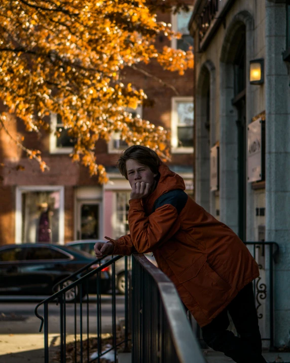 there is a woman leaning on the railing on the sidewalk