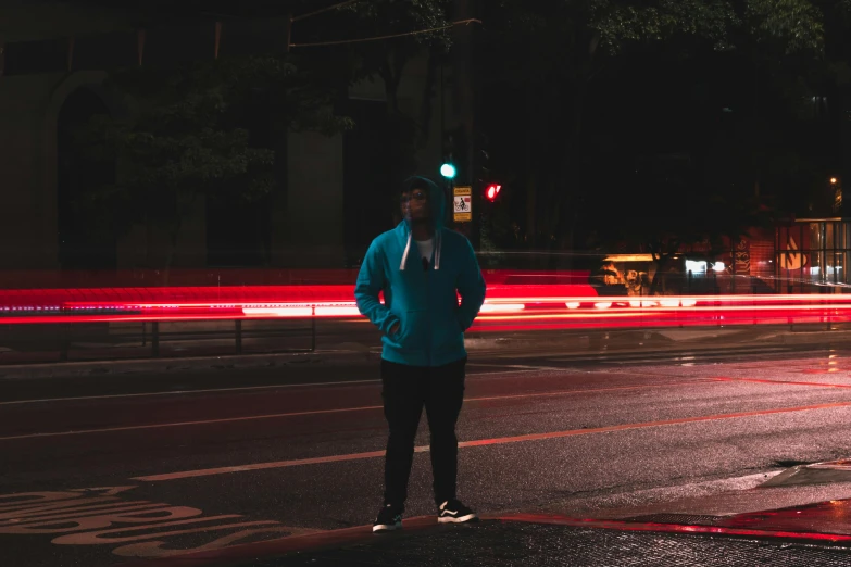 a person standing on a street corner at night