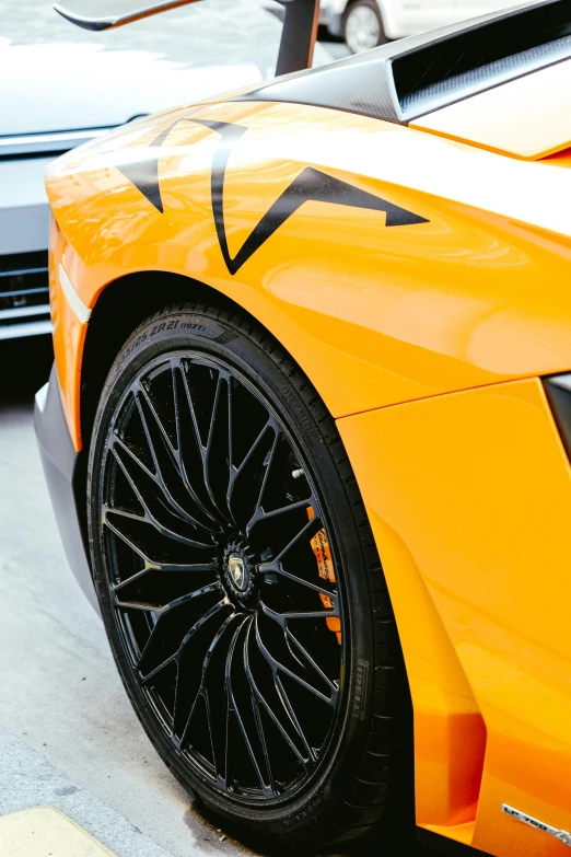 an orange sports car has stripes on it