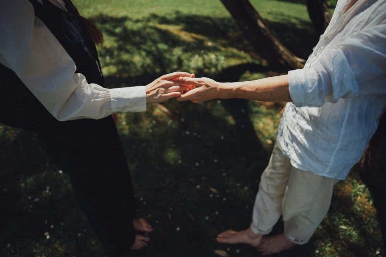 bride and groom hold hands on the lawn