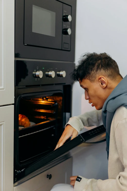 a person is looking into the oven for food