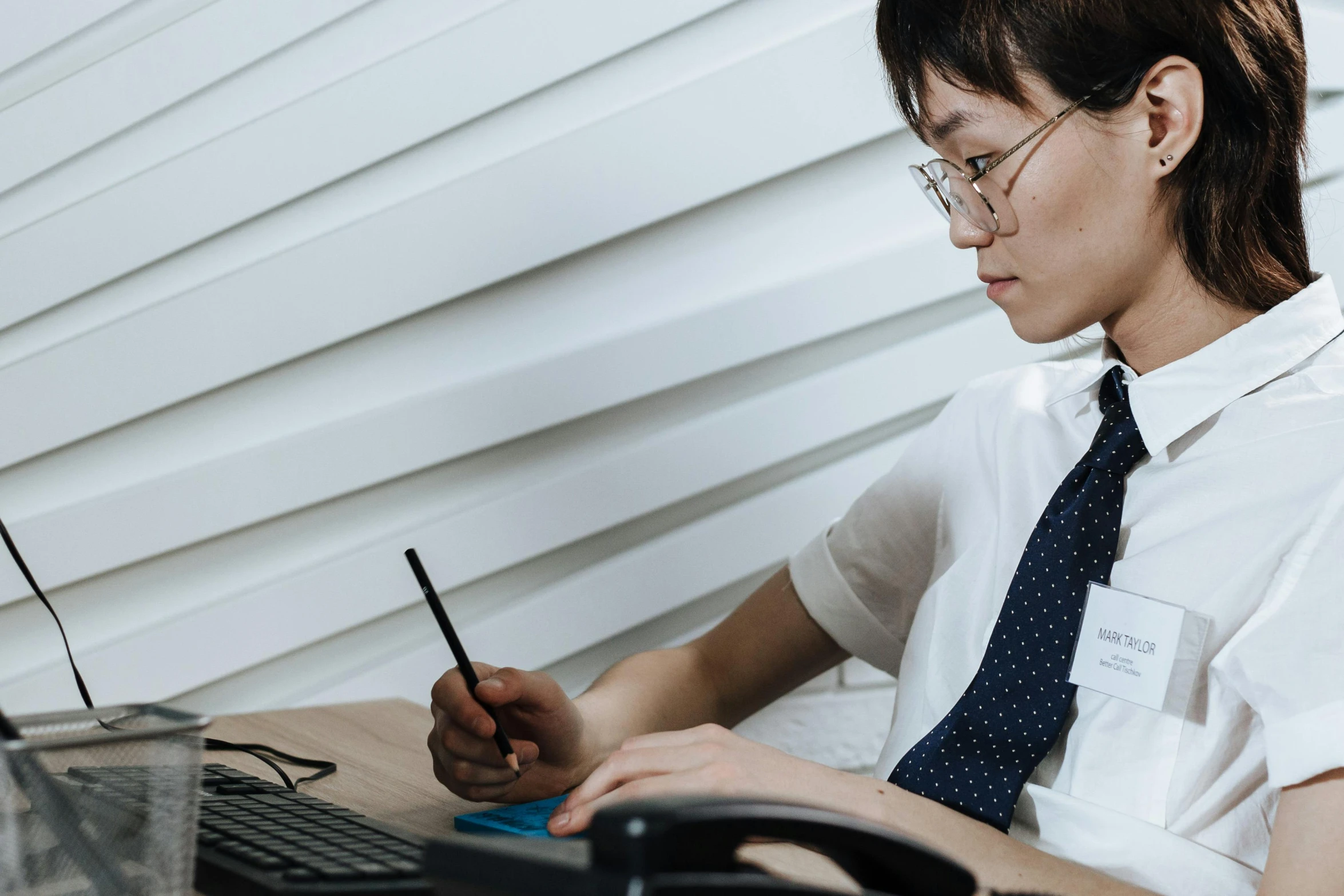 an image of woman on her cell phone at a desk