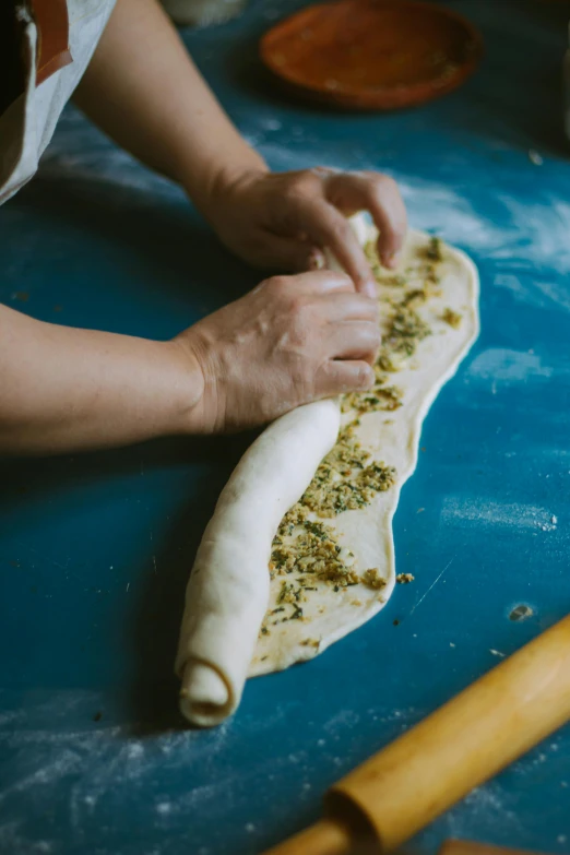 a person making bread with different kinds of toppings