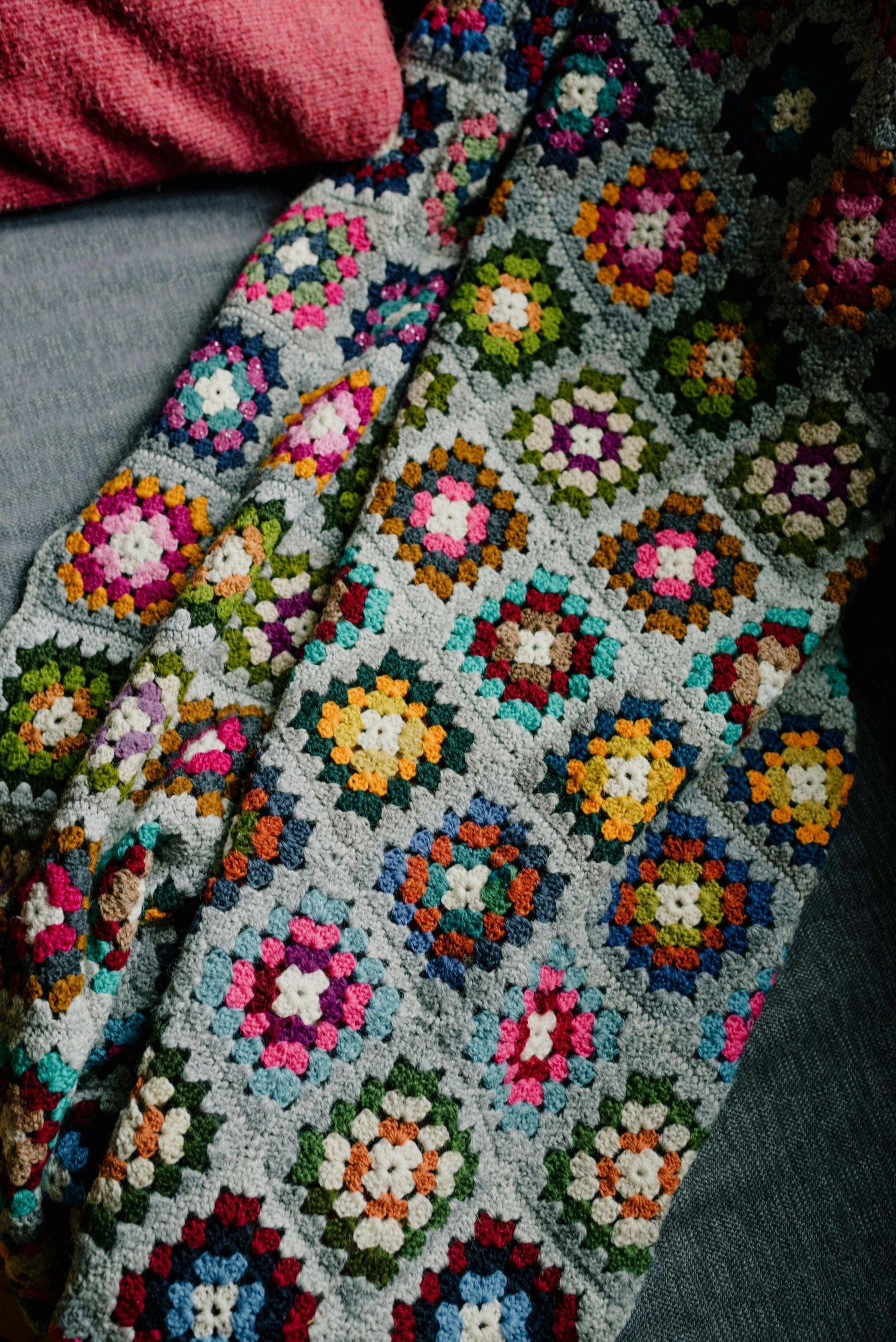 a multicolored granny granny afghan has many crocheted flowers on it