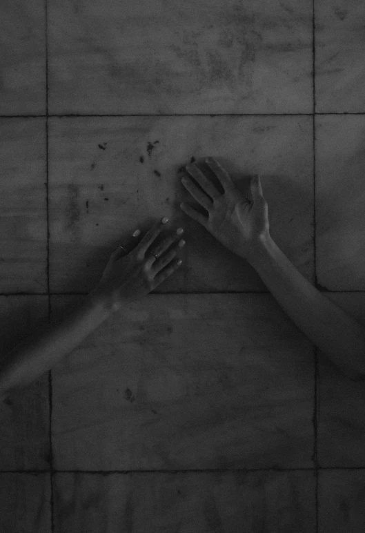 two hands reaching up toward each other in black and white