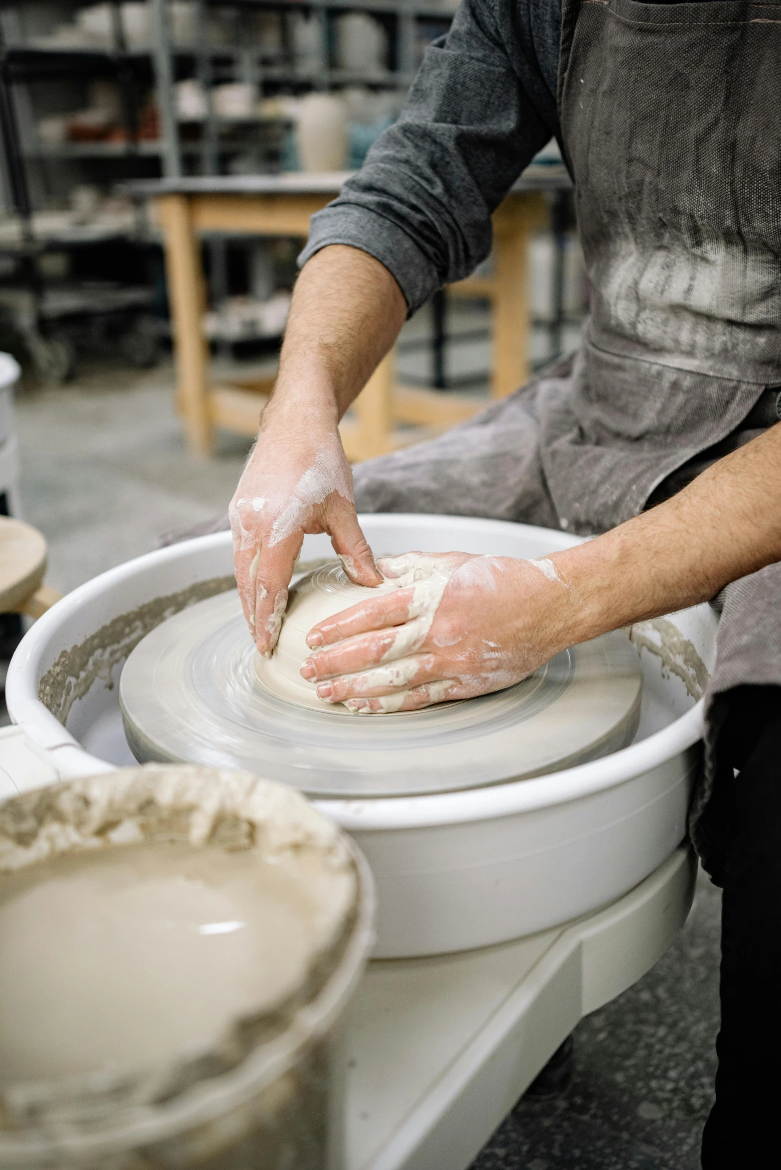 a person who is making a pot on a table