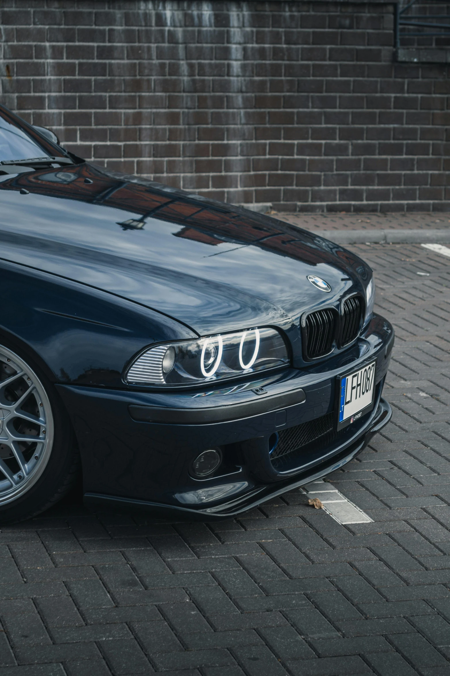 a black bmw car parked in a parking lot