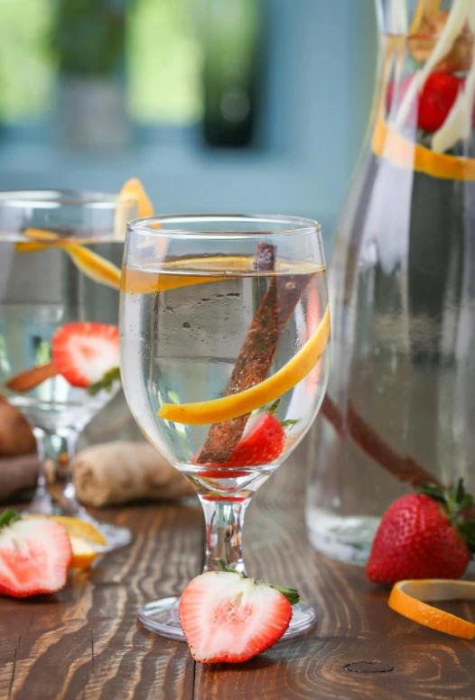 a close up of glasses on a table with fruits in them