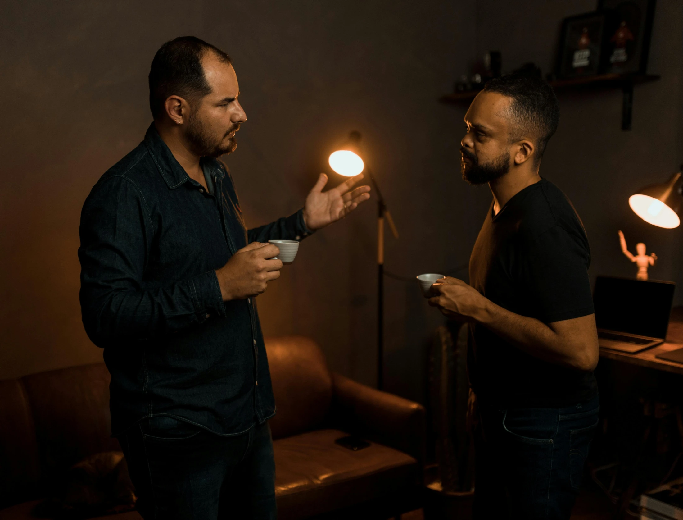 two men holding a lit object in the dark