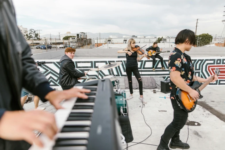 young people with instruments on a stage outdoors