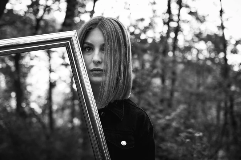 a black and white po of a person holding a picture frame