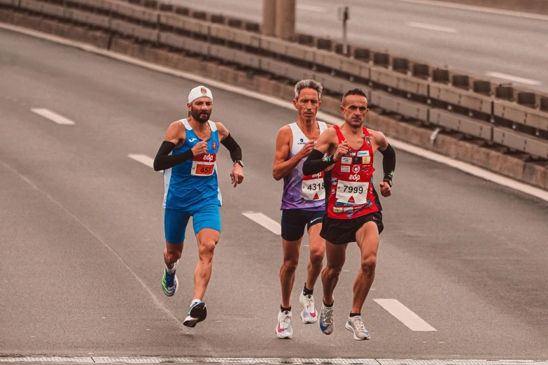 three men on a marathon running side by side