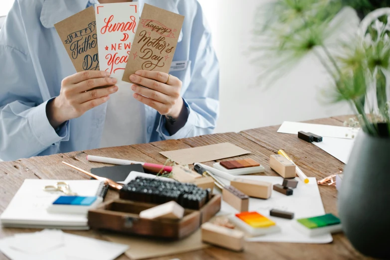 someone holding up these greeting cards on their desk