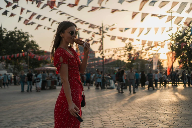 a woman walks through an outdoor festival with bunting