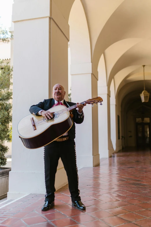 a man in a suit holding an acoustic guitar