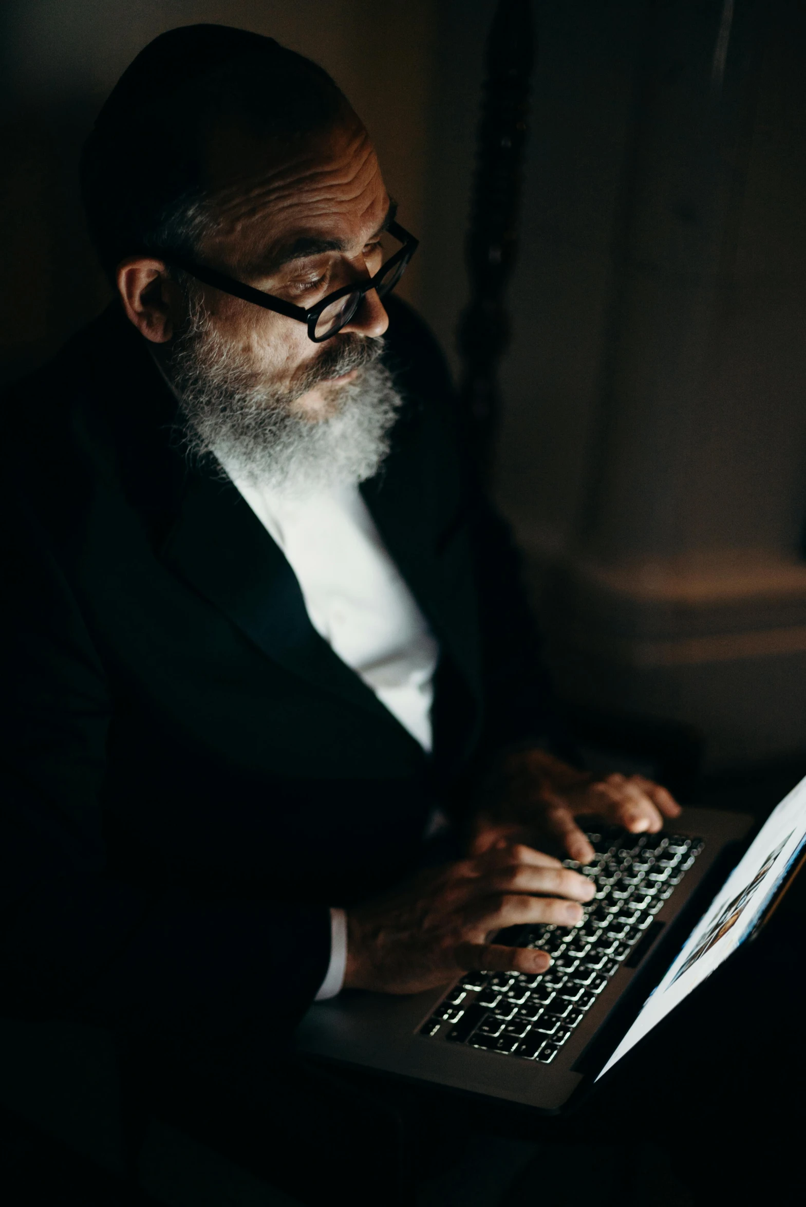 a man with a long beard is using his laptop