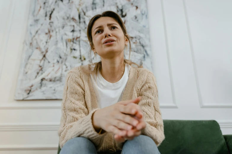 a woman sitting on top of a green couch