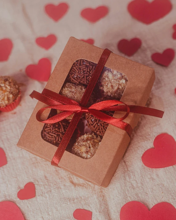 a box of nuts sitting on top of a heart - shaped table cloth