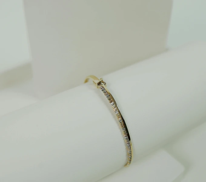 a yellow gold bang with white diamonds on it