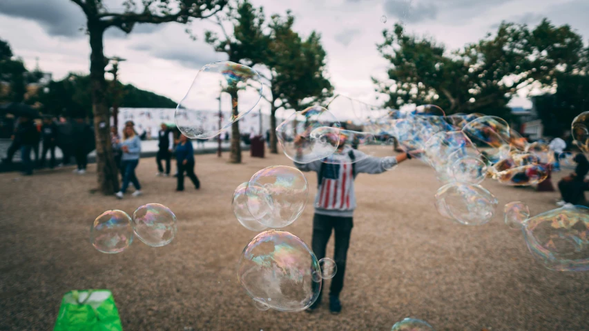 the  is holding a bunch of soap bubbles