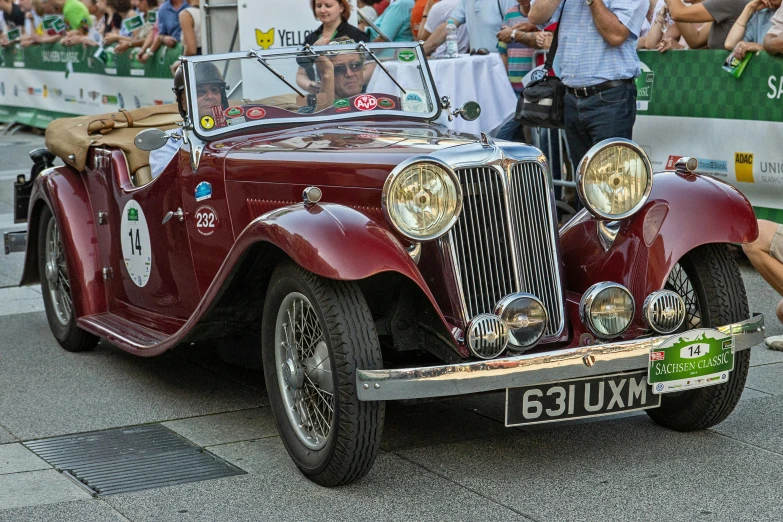 an old time style convertible car with a woman taking pictures