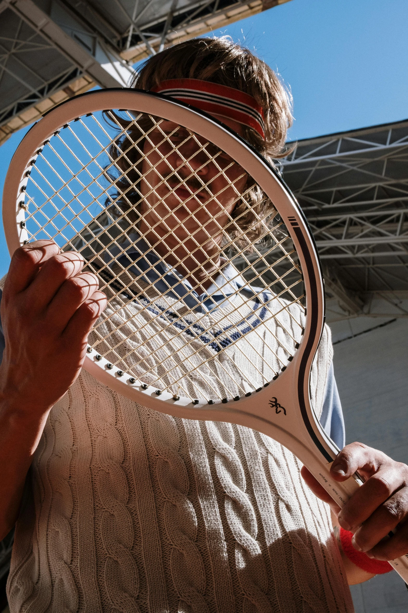 man holding a tennis racket up in front of his face